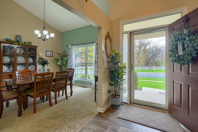 entrance foyer with high vaulted ceiling, a notable chandelier, baseboards, and wood finished floors