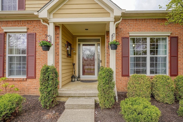 view of exterior entry featuring brick siding