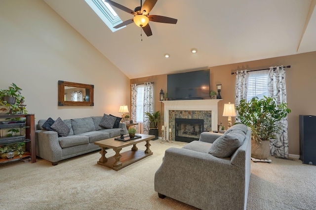 carpeted living area featuring high vaulted ceiling, plenty of natural light, a fireplace, and ceiling fan