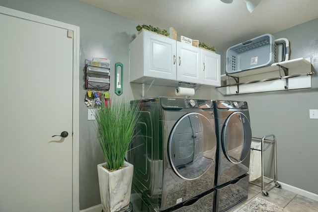 washroom featuring cabinet space, light tile patterned floors, independent washer and dryer, and baseboards