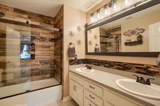 full bathroom with double vanity, a sink, visible vents, and bath / shower combo with glass door