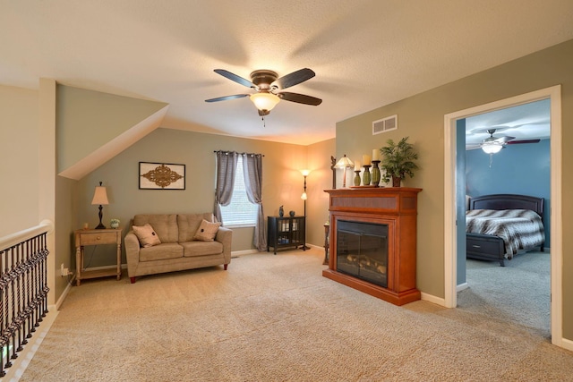 living area with visible vents, ceiling fan, light colored carpet, and baseboards