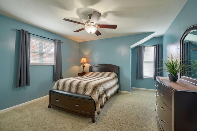 bedroom featuring light carpet, ceiling fan, and multiple windows