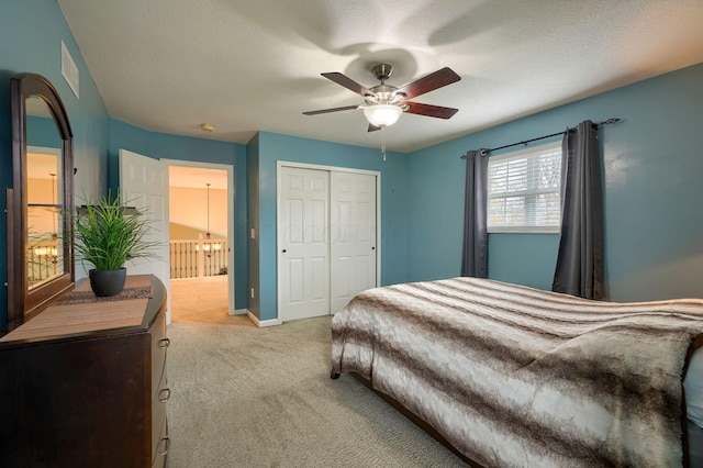 bedroom featuring a closet, baseboards, light carpet, visible vents, and ceiling fan