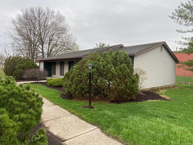 view of side of home with a yard