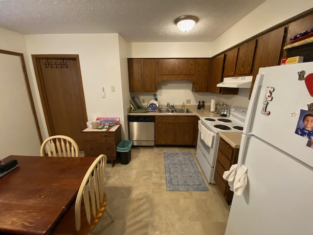 kitchen featuring white appliances, a textured ceiling, under cabinet range hood, light countertops, and a sink