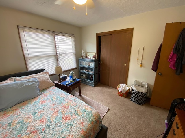 bedroom with a closet, a ceiling fan, and light carpet