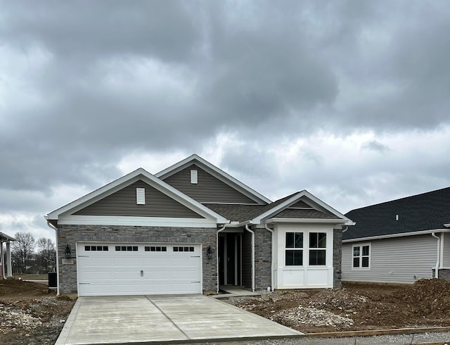 ranch-style home with stone siding, a garage, concrete driveway, and roof with shingles