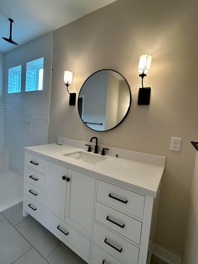 full bath featuring tile patterned floors, vanity, and tiled shower