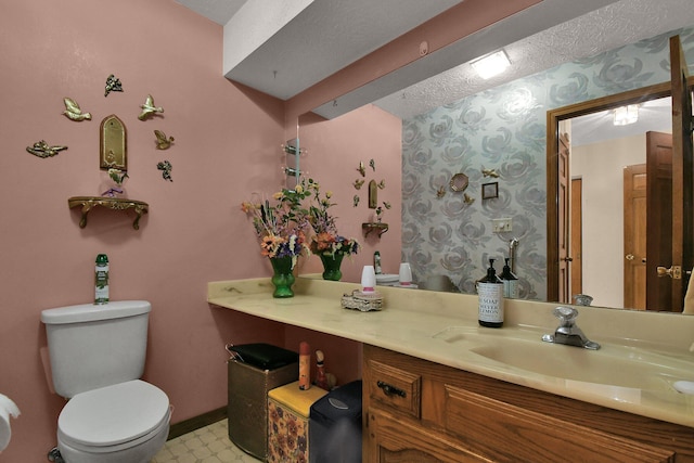 2520 Mccutcheon Rd, Columbus, OH 43219 - bathroom with vanity, toilet, baseboards, wallpapered walls, and a textured ceiling