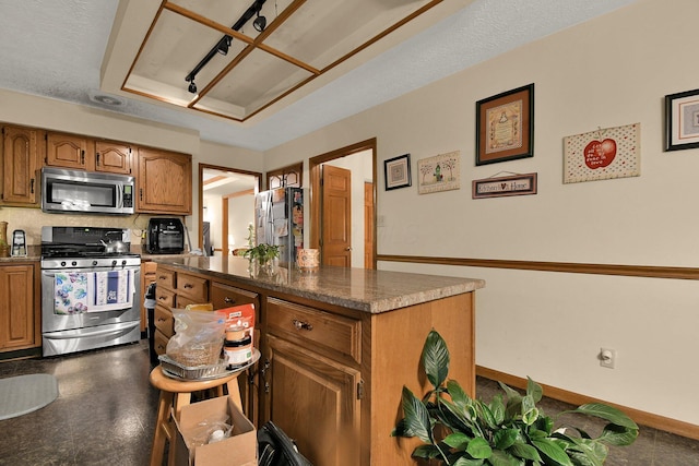 2520 Mccutcheon Rd, Columbus, OH 43219 - kitchen with a center island, baseboards, brown cabinets, and stainless steel appliances