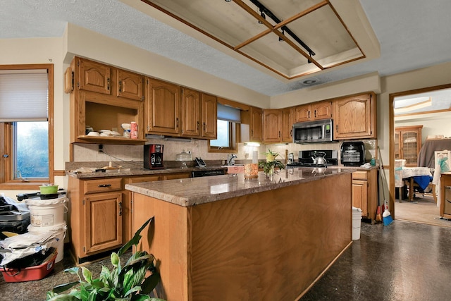 2520 Mccutcheon Rd, Columbus, OH 43219 - kitchen featuring a kitchen island, stove, stainless steel microwave, and decorative backsplash