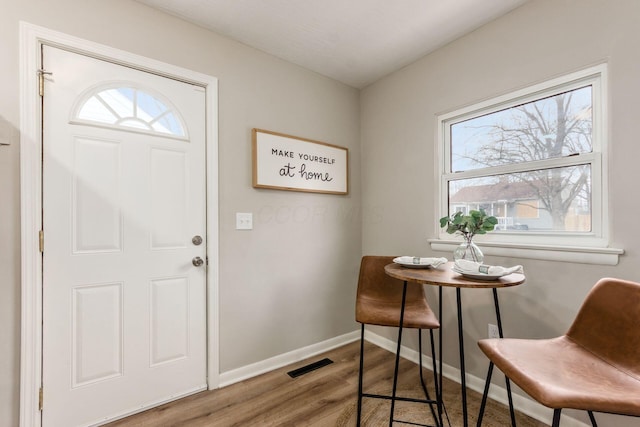 entrance foyer with wood finished floors, baseboards, and visible vents