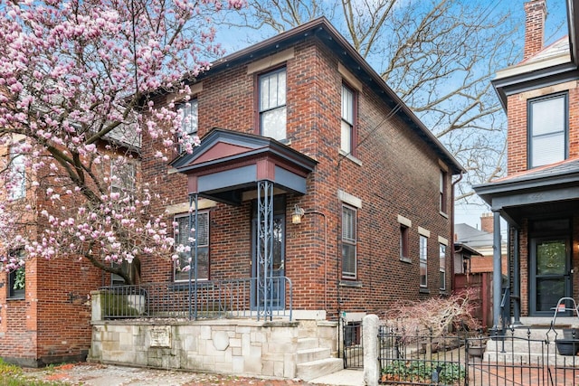 view of front facade with fence and brick siding