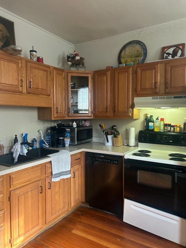 kitchen with stainless steel microwave, light countertops, under cabinet range hood, range with electric cooktop, and dishwashing machine