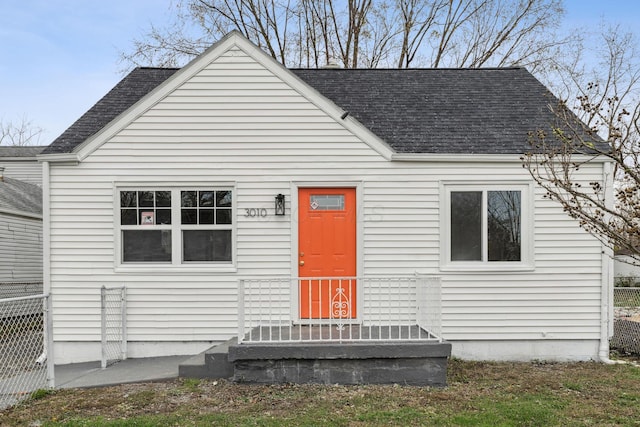 view of front of property with fence and roof with shingles
