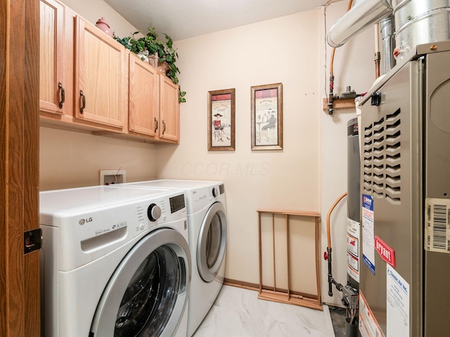 laundry area featuring marble finish floor, washer and clothes dryer, heating unit, and cabinet space