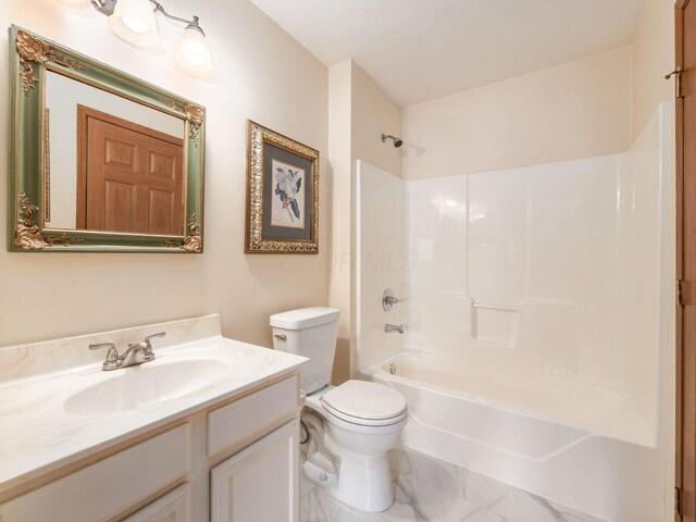 full bath with toilet, marble finish floor, vanity, and shower / bathtub combination