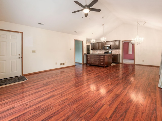 unfurnished living room featuring visible vents, baseboards, dark wood-style floors, and ceiling fan with notable chandelier