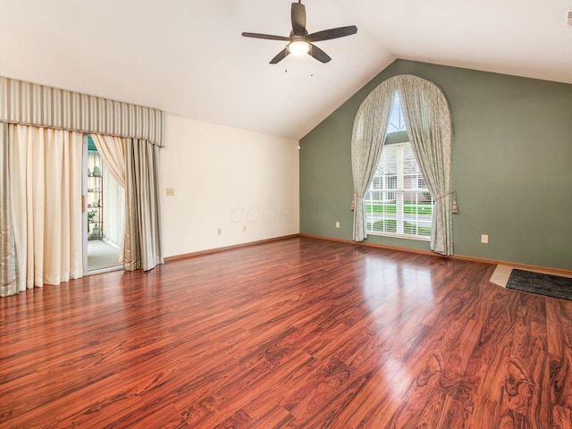 spare room featuring wood finished floors, ceiling fan, baseboards, and lofted ceiling