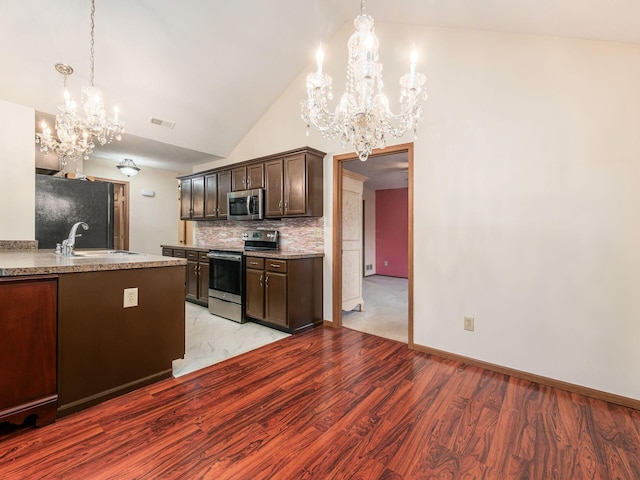 kitchen featuring visible vents, a sink, a chandelier, dark brown cabinets, and stainless steel appliances
