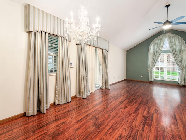spare room featuring wood finished floors, ceiling fan with notable chandelier, baseboards, and lofted ceiling