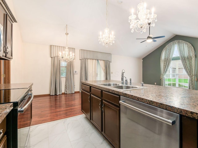 kitchen featuring ceiling fan with notable chandelier, dark brown cabinets, a sink, lofted ceiling, and stainless steel appliances