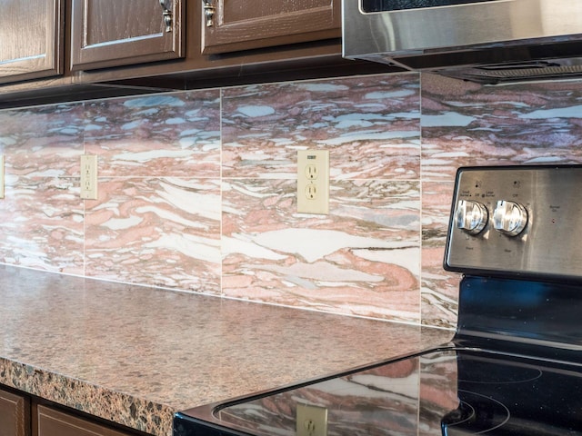 interior details with backsplash and dark brown cabinets