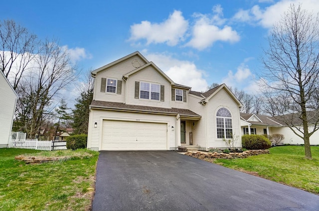 traditional home featuring driveway, an attached garage, fence, and a front yard