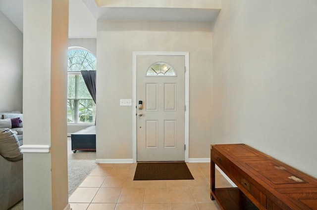 foyer entrance with light tile patterned floors and baseboards