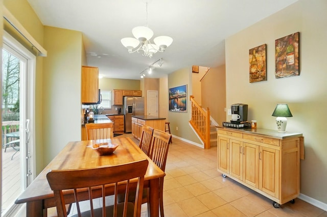 dining space featuring light tile patterned floors, stairs, baseboards, and a notable chandelier