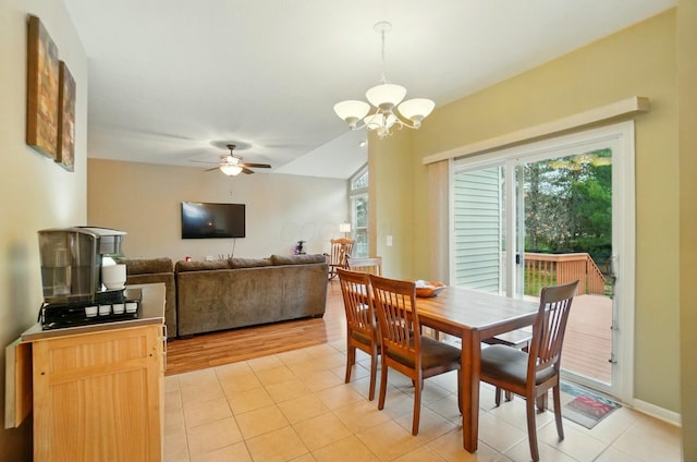 dining space featuring light tile patterned floors and ceiling fan with notable chandelier