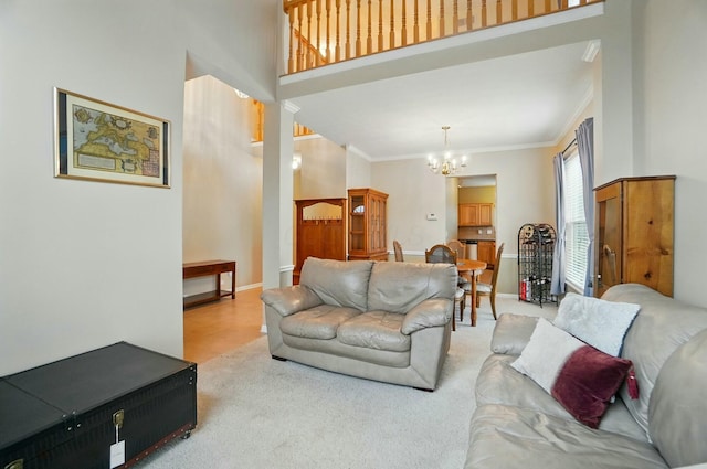 living room featuring baseboards, carpet floors, ornamental molding, and a notable chandelier