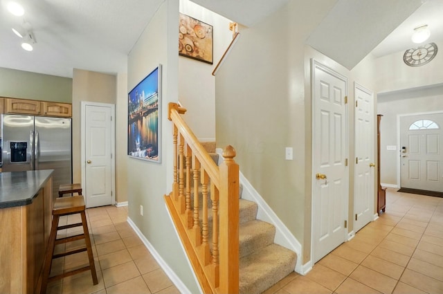 staircase featuring tile patterned flooring and baseboards