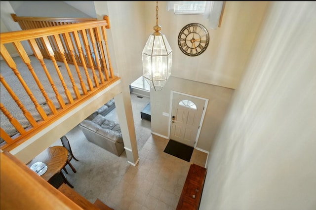 foyer featuring a towering ceiling, baseboards, and stairs