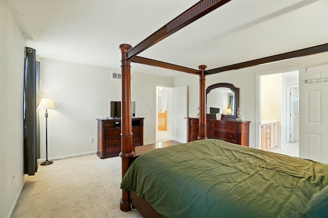 bedroom featuring ensuite bath, baseboards, light colored carpet, and visible vents