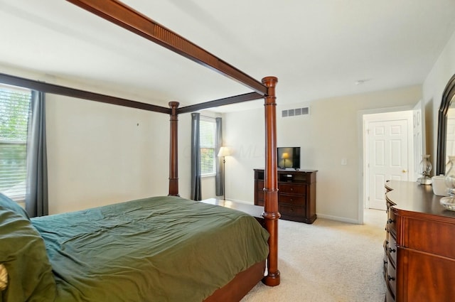 bedroom featuring baseboards, light colored carpet, and visible vents