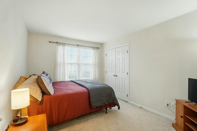 carpeted bedroom with baseboards and a closet