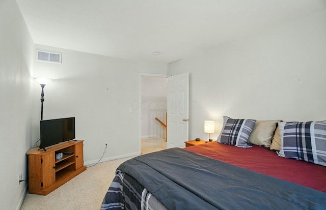 bedroom with baseboards, visible vents, and carpet
