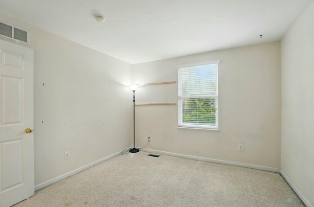 unfurnished room featuring baseboards, visible vents, and carpet
