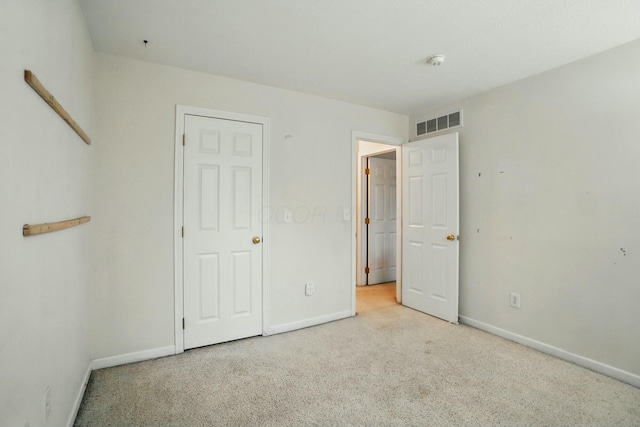 unfurnished bedroom featuring baseboards, visible vents, and carpet flooring