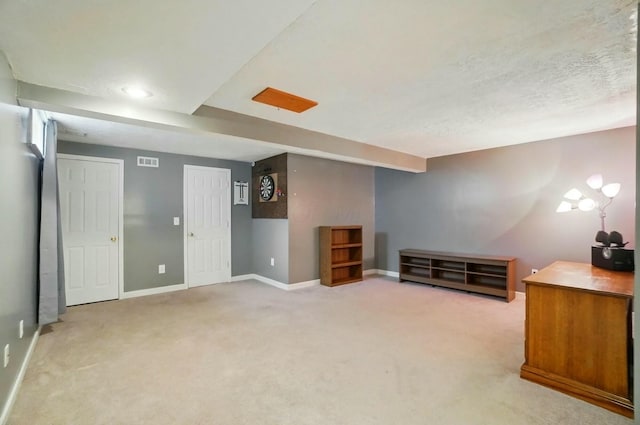 interior space with a textured ceiling, baseboards, and visible vents