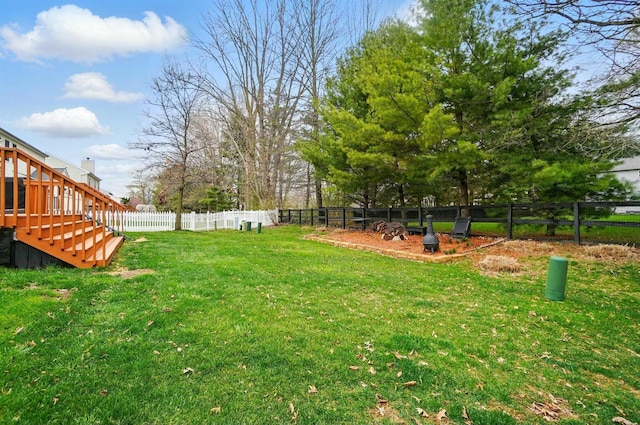 view of yard with a fenced backyard and stairway