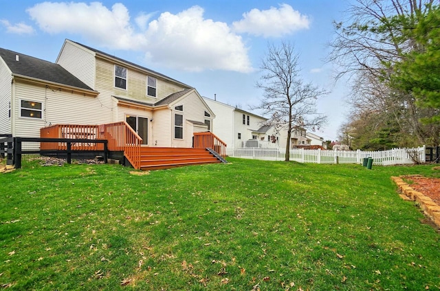 rear view of house with fence private yard, a yard, and a wooden deck