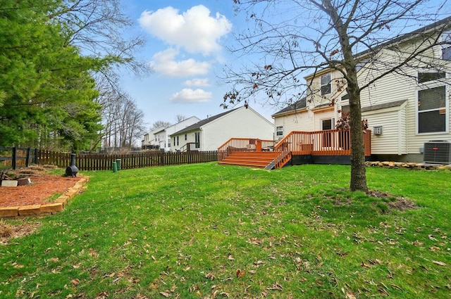 view of yard with a fenced backyard, a wooden deck, and central AC