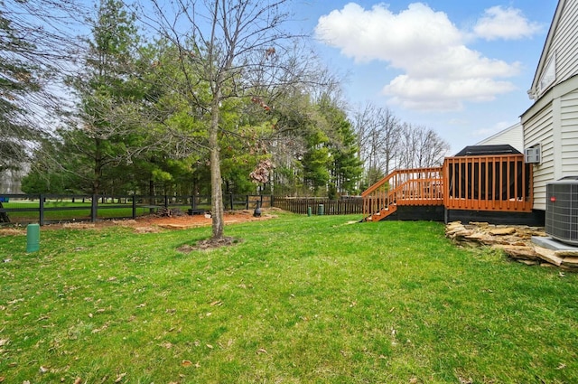 view of yard with a fenced backyard, central AC unit, and a wooden deck