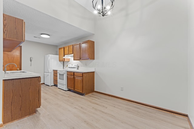 478 Three Oaks Ct, Columbus, OH 43230 - kitchen with white appliances, under cabinet range hood, light wood-style floors, a sink, and brown cabinets
