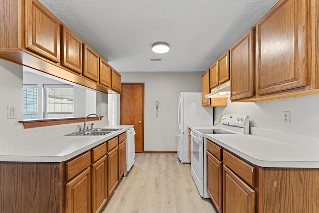 478 Three Oaks Ct, Columbus, OH 43230 - kitchen featuring white appliances, a sink, light wood-style flooring, brown cabinetry, and a textured ceiling