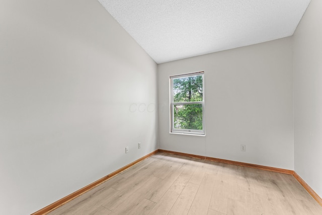 478 Three Oaks Ct, Columbus, OH 43230 - spare room with light wood-style flooring, baseboards, lofted ceiling, and a textured ceiling