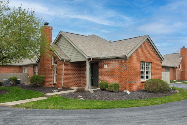 3870 Sandstone Cir, Powell, OH 43065 - ranch-style house featuring fence, a chimney, brick siding, and central AC